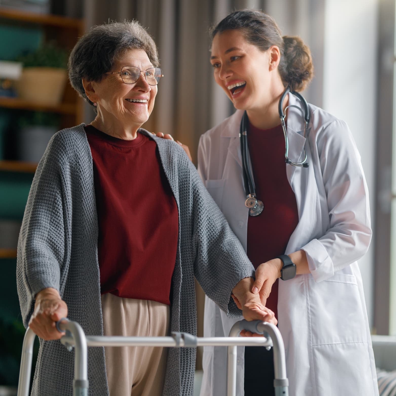 A physician in a white coat helping an older woman using a walker at home